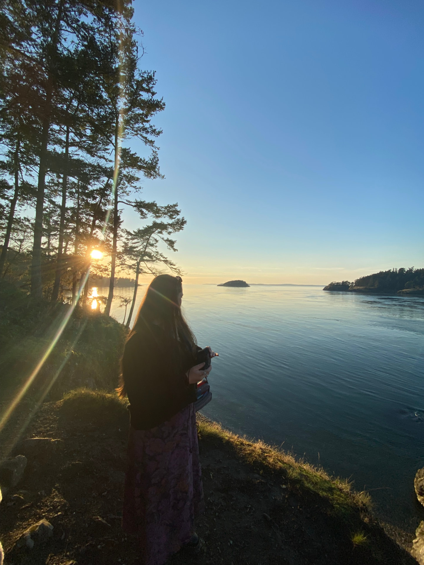Dr. Rachel Whyte pausing beside the water at sunset